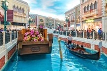 Gondolier rides tourists on a gondola along the mock canal of the Venetian Macao Resort Gondolier rides tourists on a gondola along the mock canal of the Venetian Macao Resort